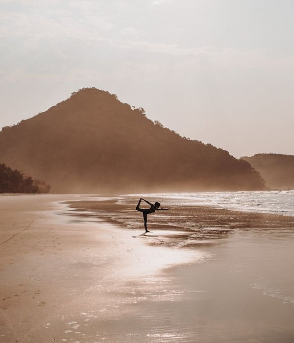 Woman in a calm yoga pose against a light graphite background with sea foam accents.